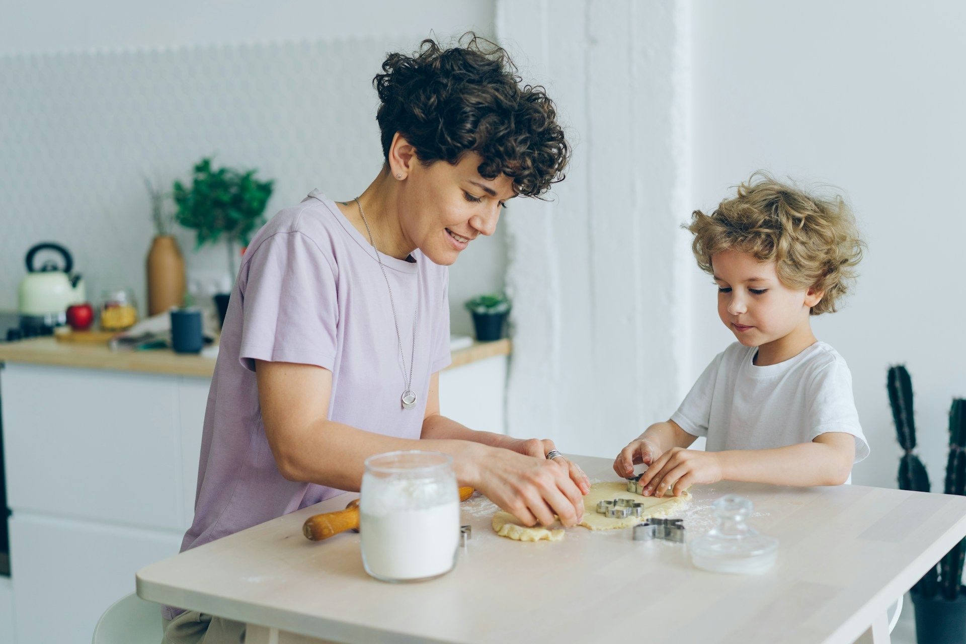 Adult and child bake together in a kitchen.