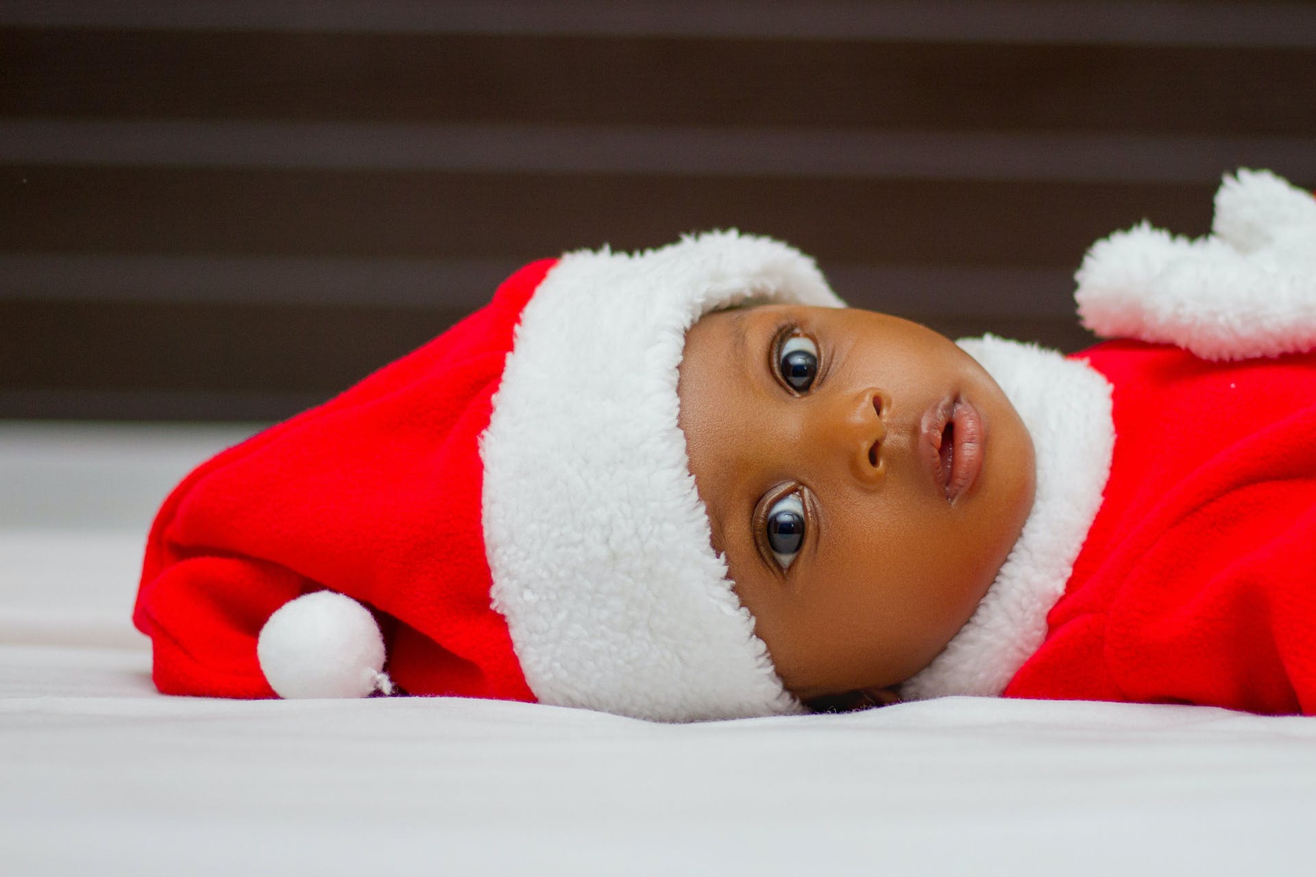 Baby wearing Christmas hat.