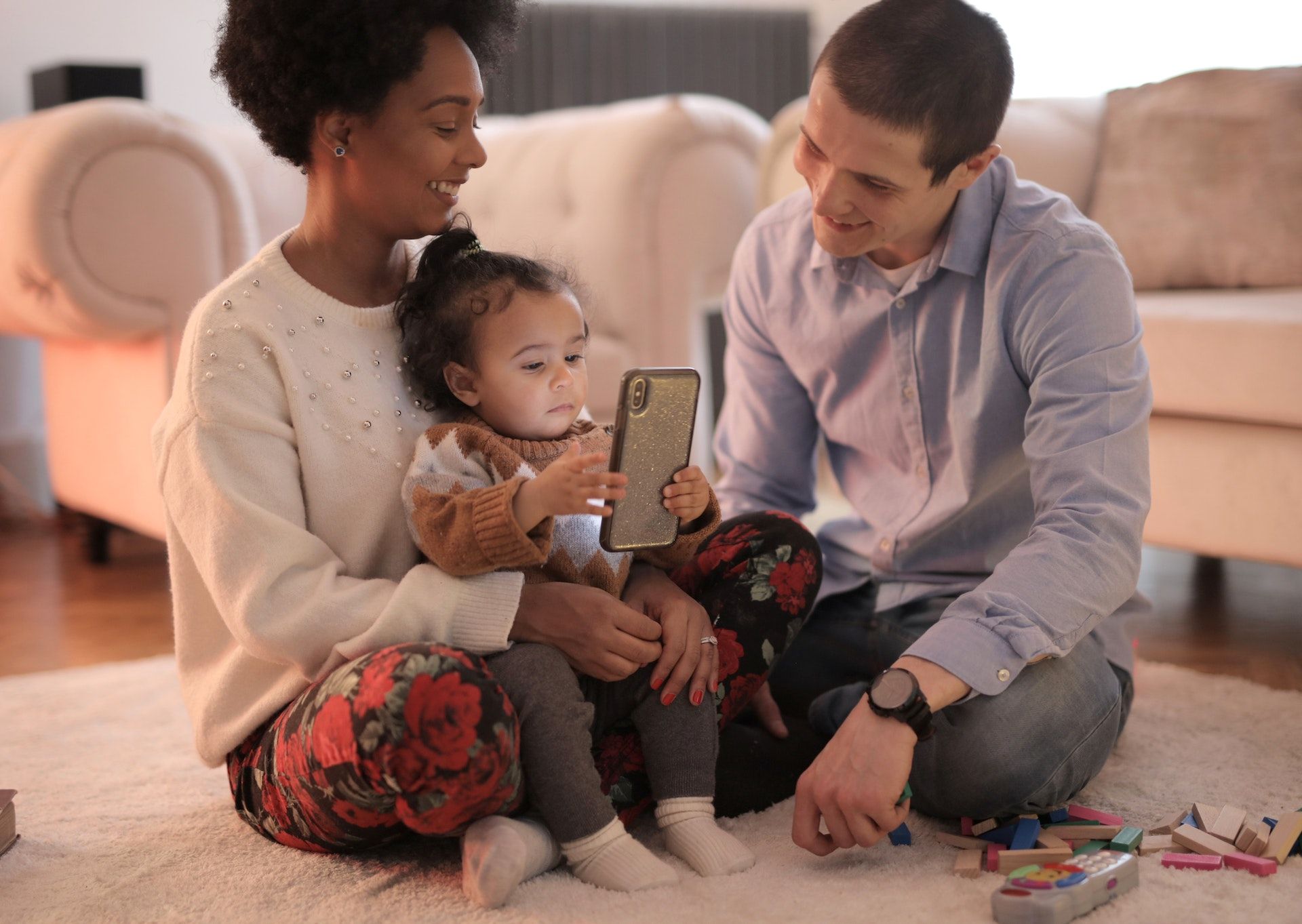 Baby uses phone with parents.