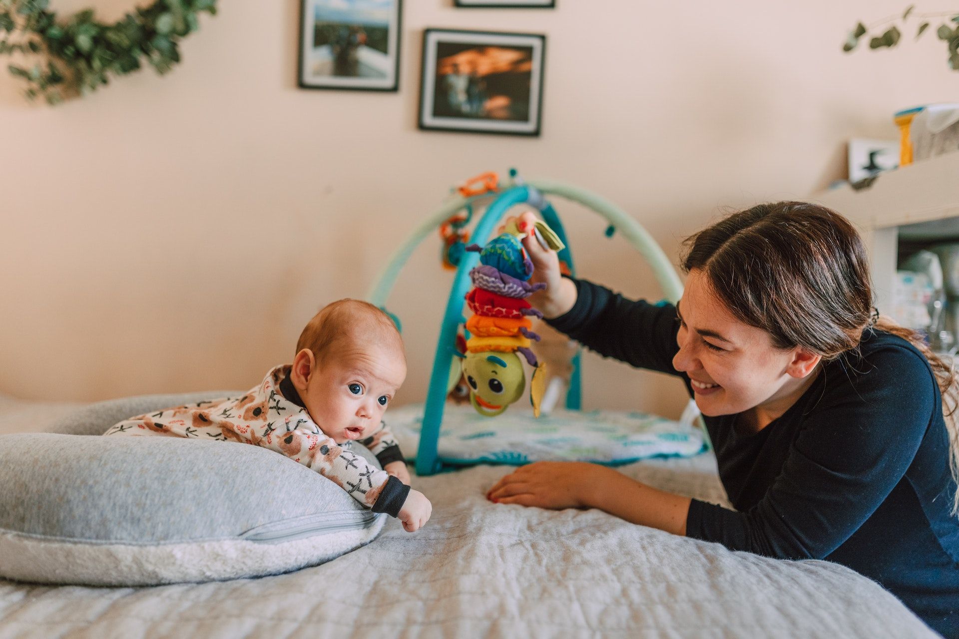 A newborn baby is sat in a donut cushion experiencing sensory play.