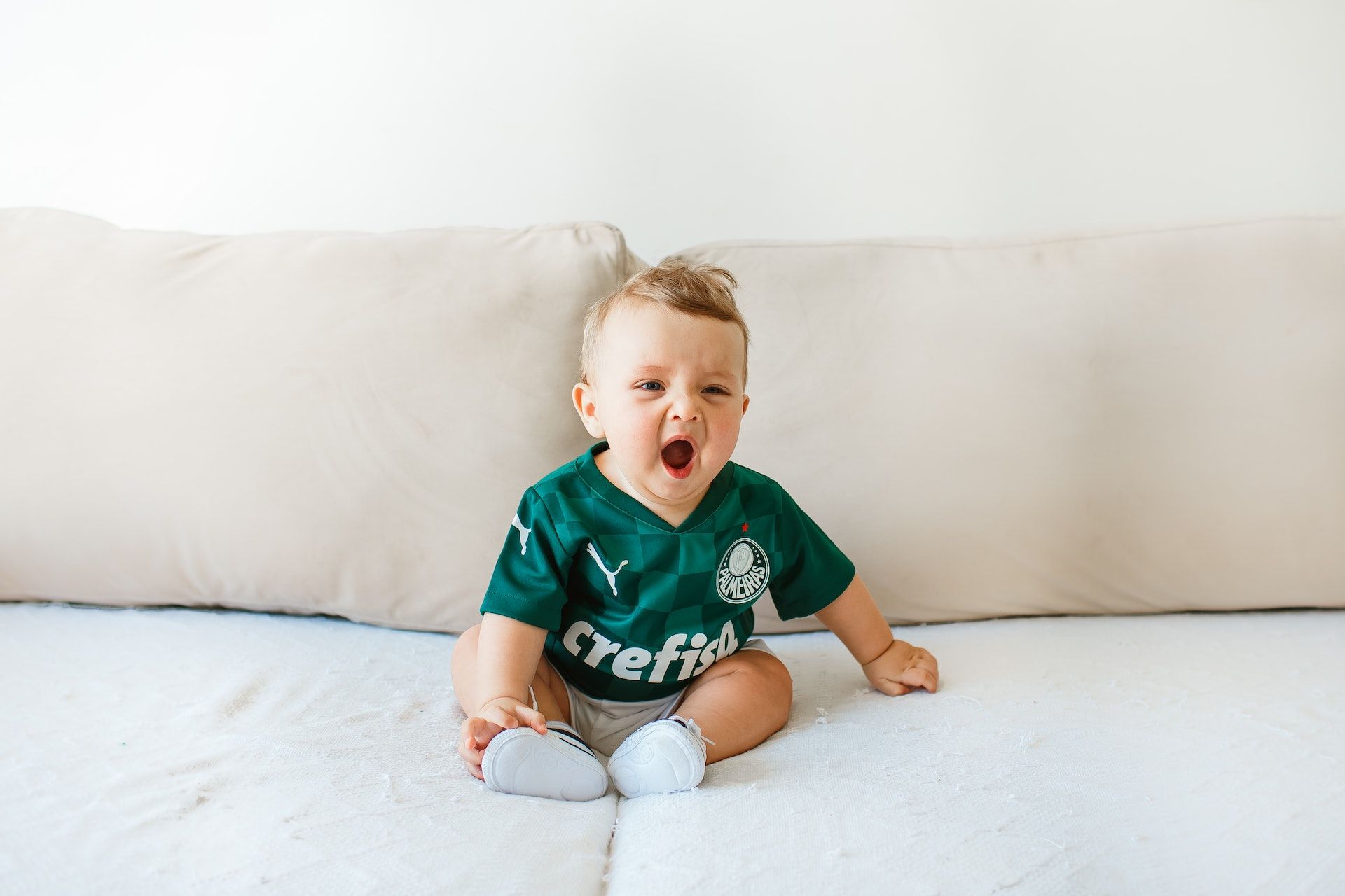 Boy yawns on sofa.