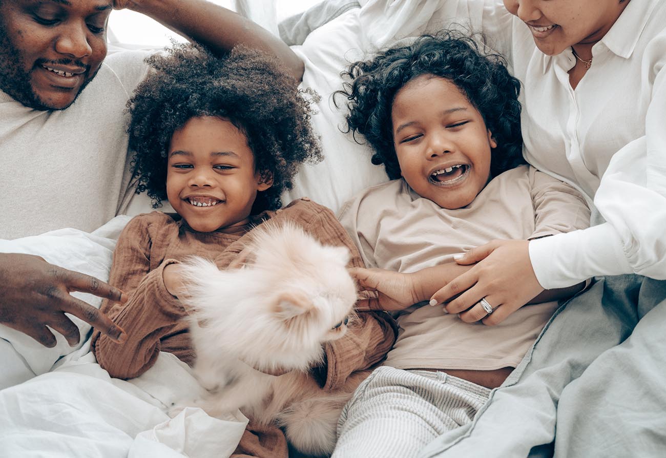 parents lying down with two children all laughing together