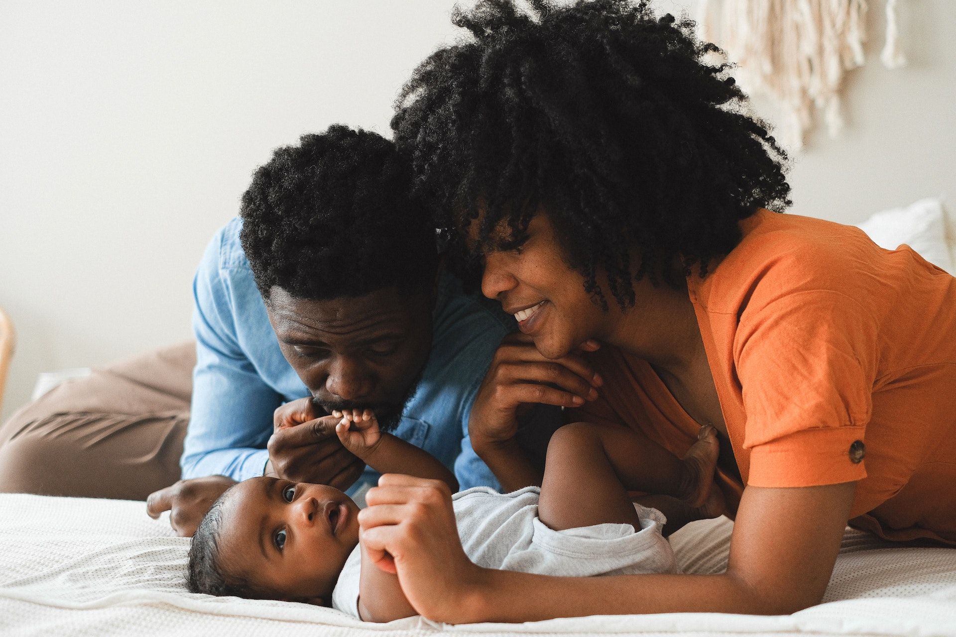 Family with baby on bed.