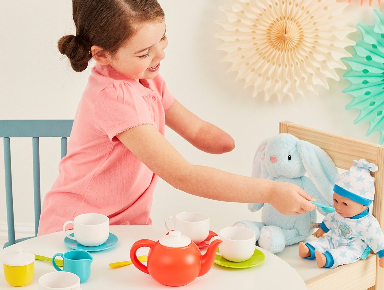 Girl plays tea time with dolls.