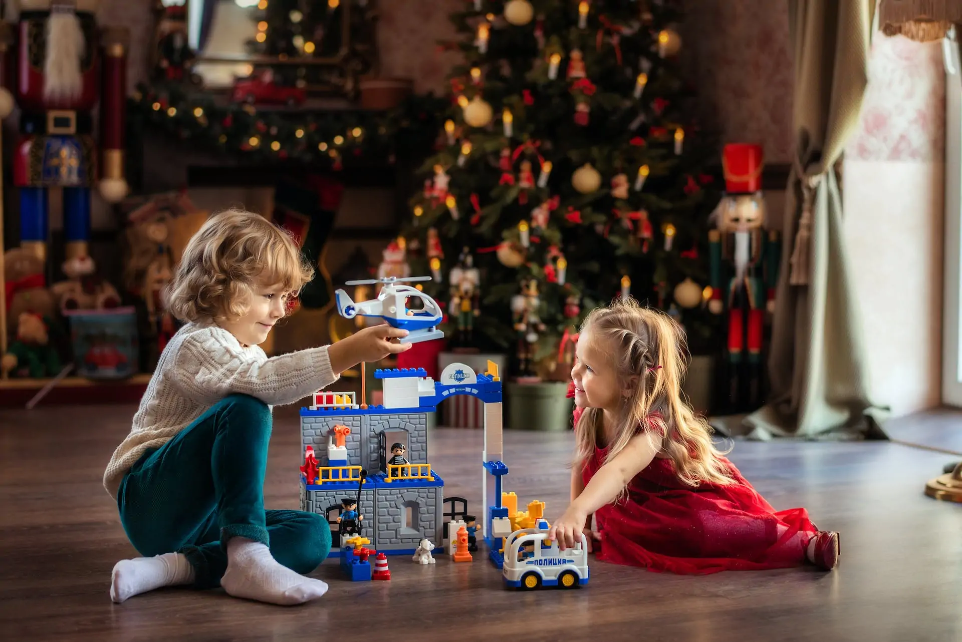 Children playing by Christmas tree.