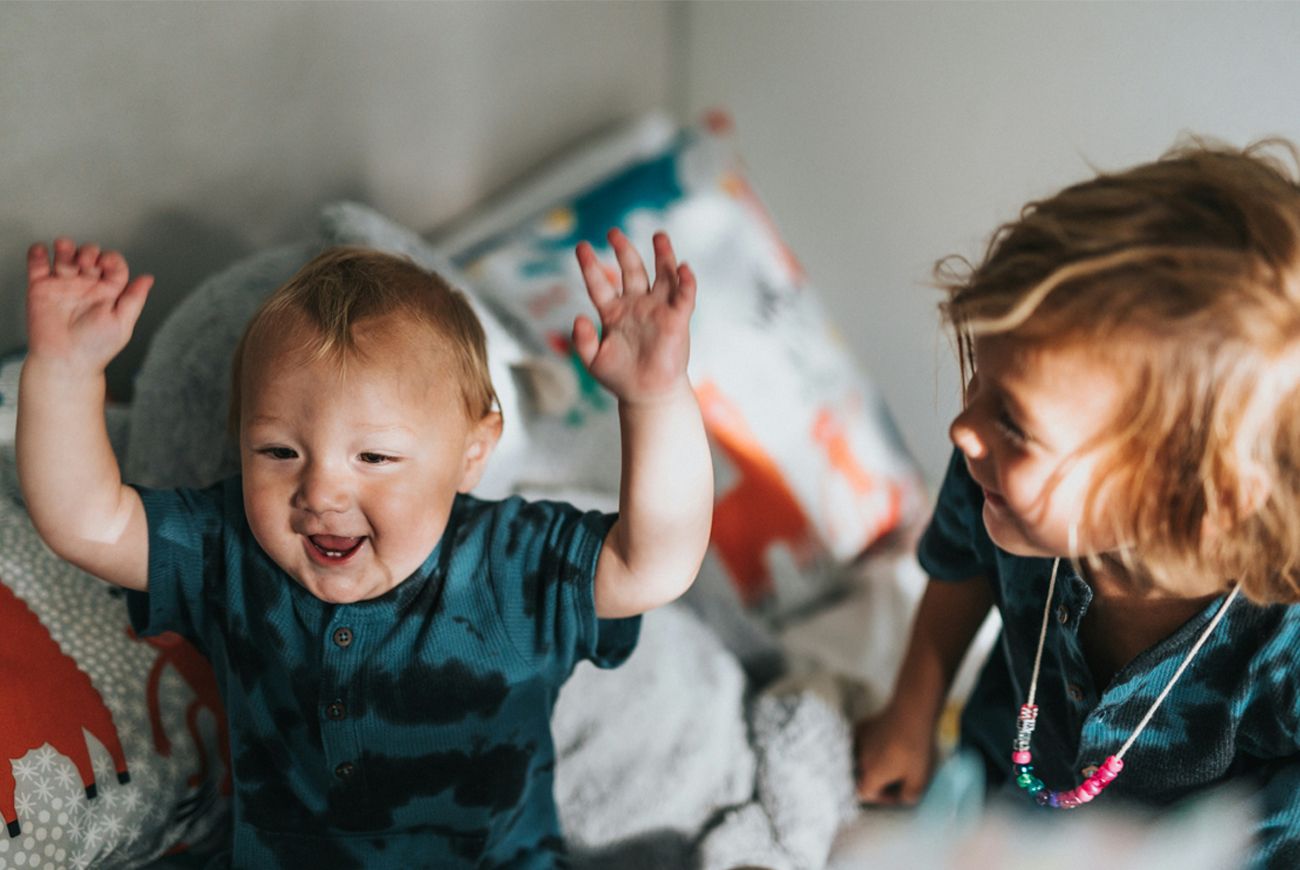 Two small children playing laughing dancing