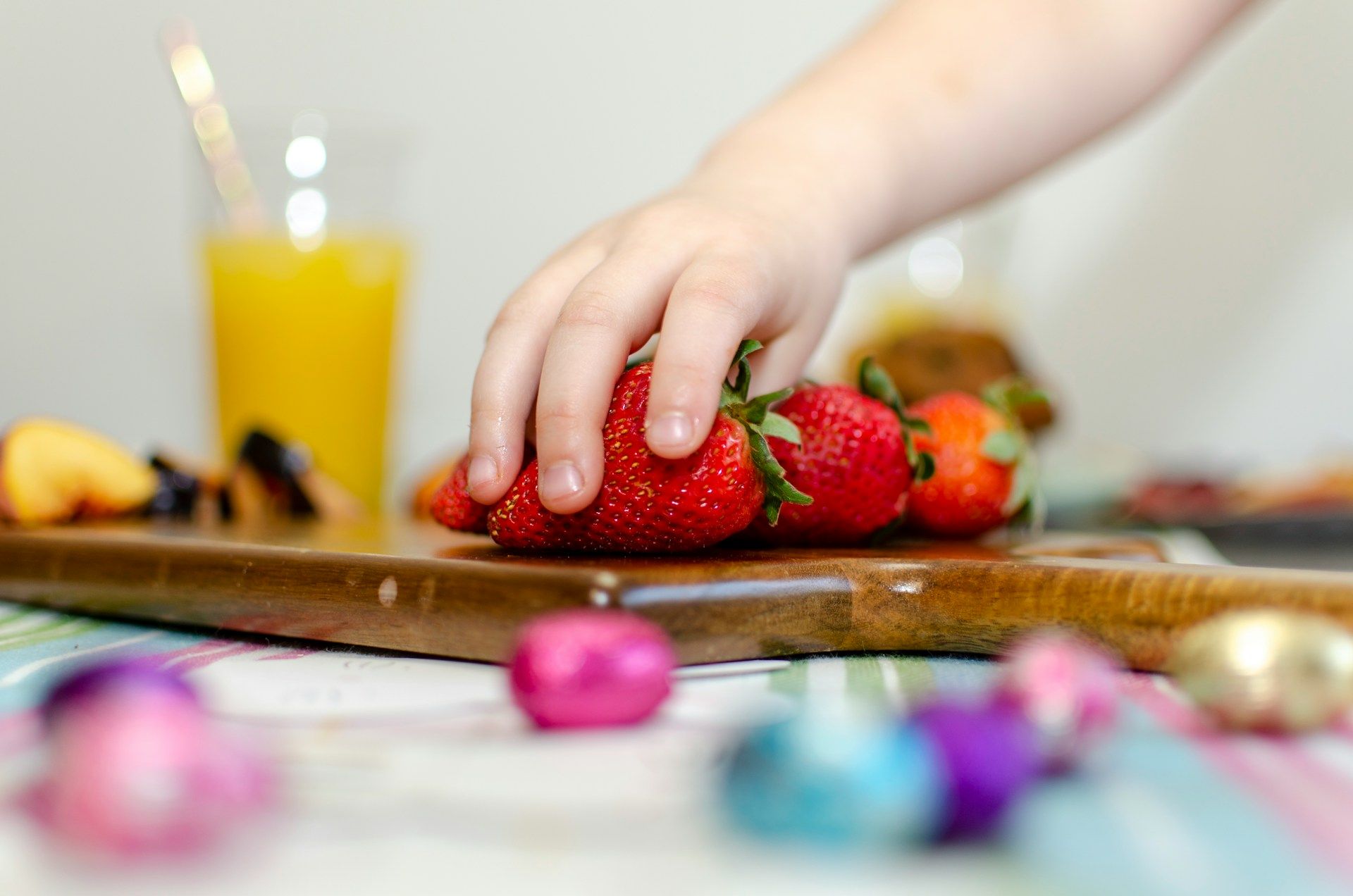 A child reaches out for strawberries.