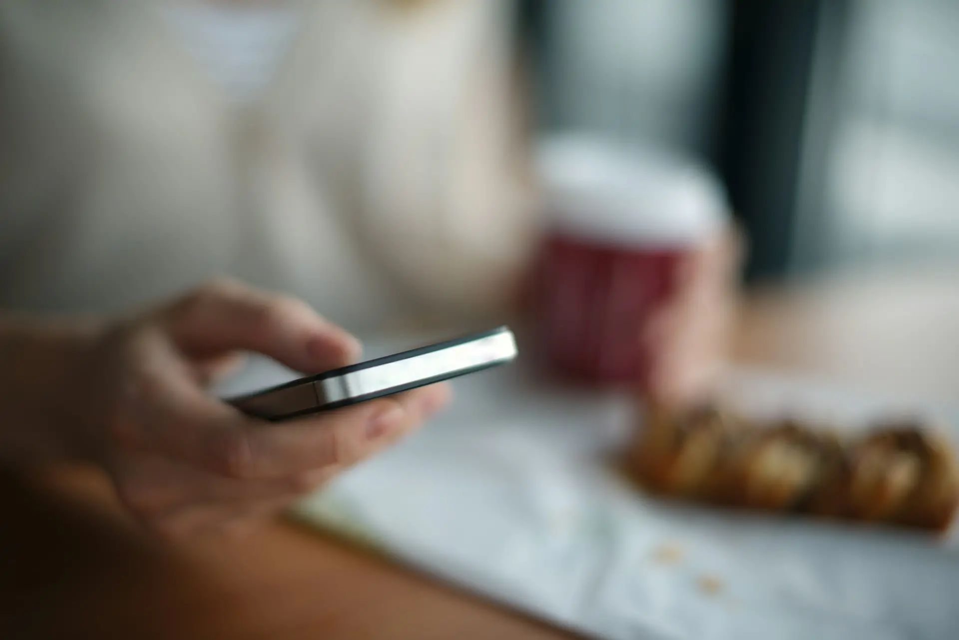 A hand is shown holding a phone as if texting.