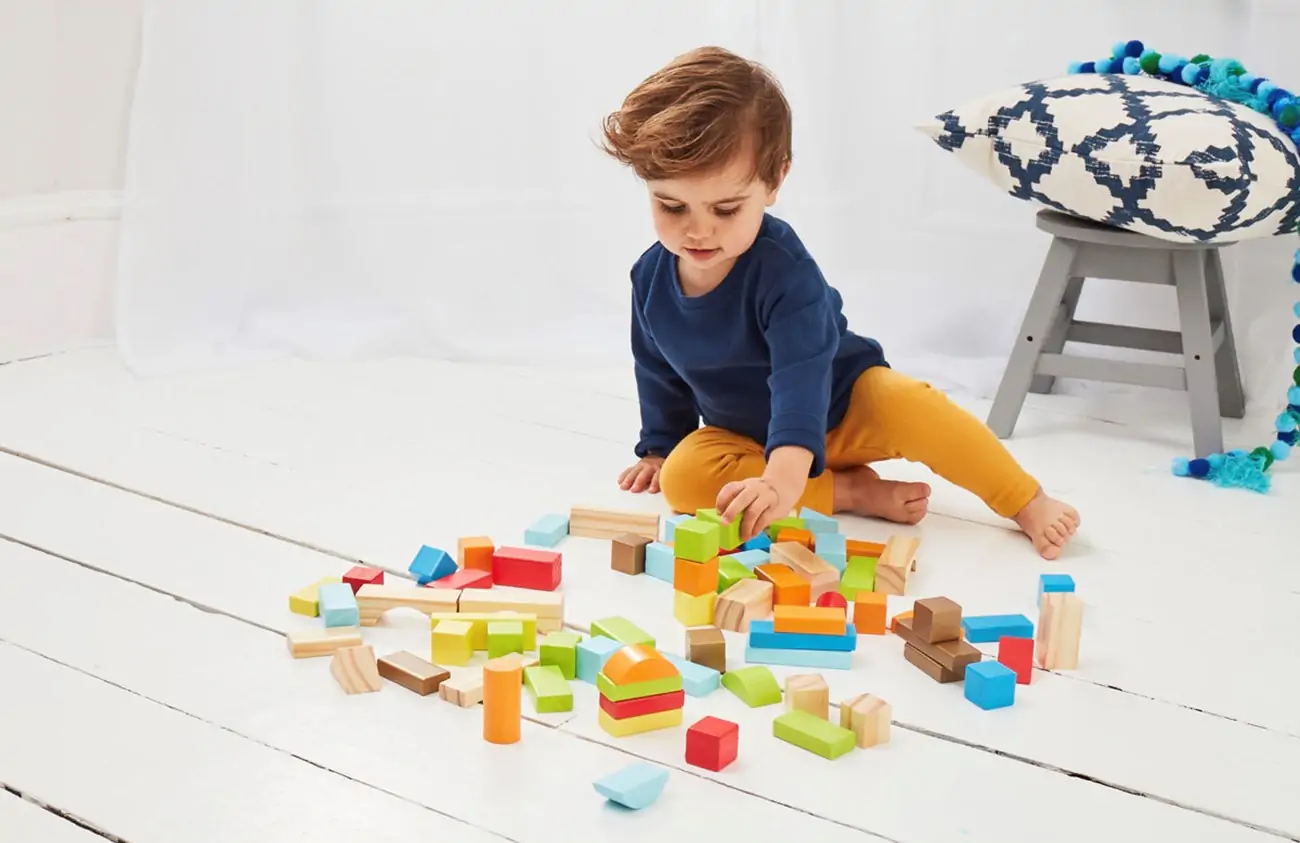 Child plays with wooden bricks.