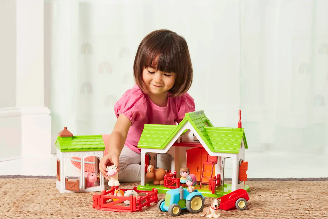 Girl playing with animal farm set