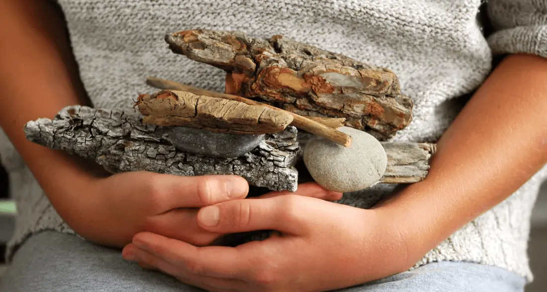 Small child holding stones in their hands