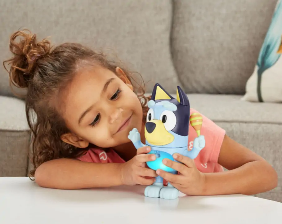 Young child plays with Bluey toys.